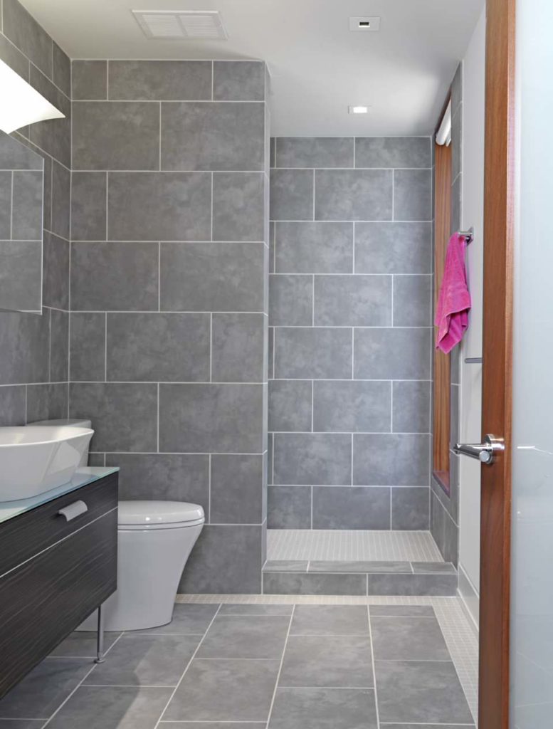 小浴室，大面积的灰色瓷砖墙和地板