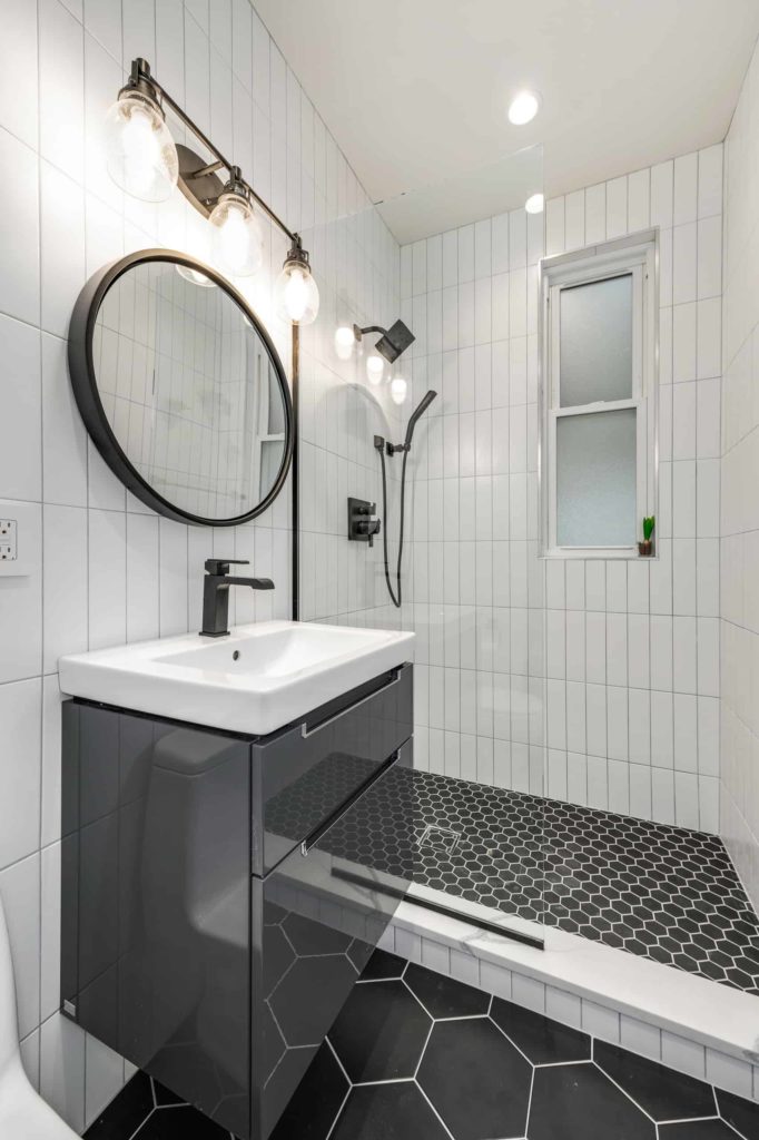 现代浴室，白色瓷砖墙，黑色六角瓷砖地板