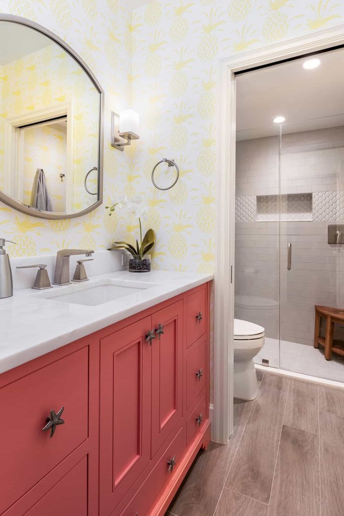 白色瓷砖淋浴，珊瑚色橱柜，黄色菠萝图案壁纸